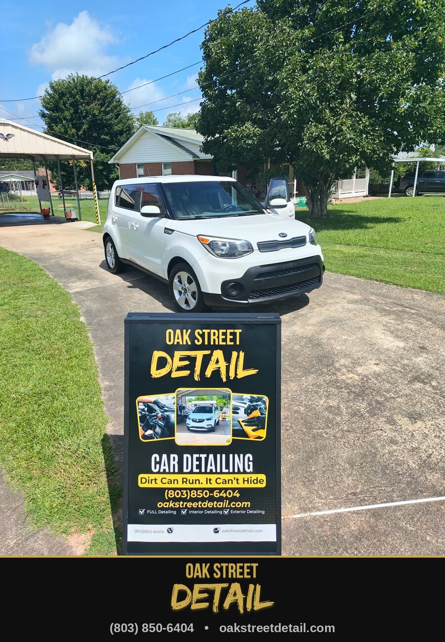 White Kia Soul freshly detailed behind the Oak Street Detail sign